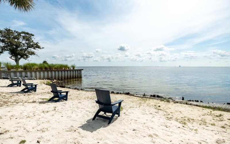 a private beach with Adirondack chairs